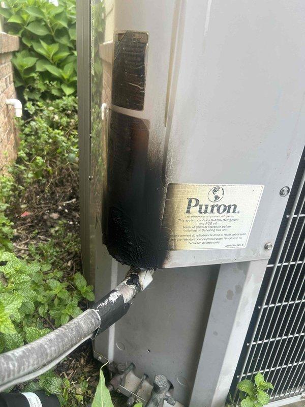 Responded to no cooling complaint on Puron system. Upon arrival, discovered catastrophic electrical failure in outdoor unit's control compartment with extensive fire damage. Contactor, capacitor, and control wiring sustained severe heat damage with melted insulation, charred components, and fused connections. External evidence of electrical fire visible with significant soot and burn marks on adjacent wall above unit. All damaged electrical components including contactor, capacitor, and control wiring harness require complete replacement. Compartment interior shows heat discoloration and corrosion throughout. System remains inoperable and unsafe for operation until full electrical component replacement completed. Documented extensive damage with photos for reference.