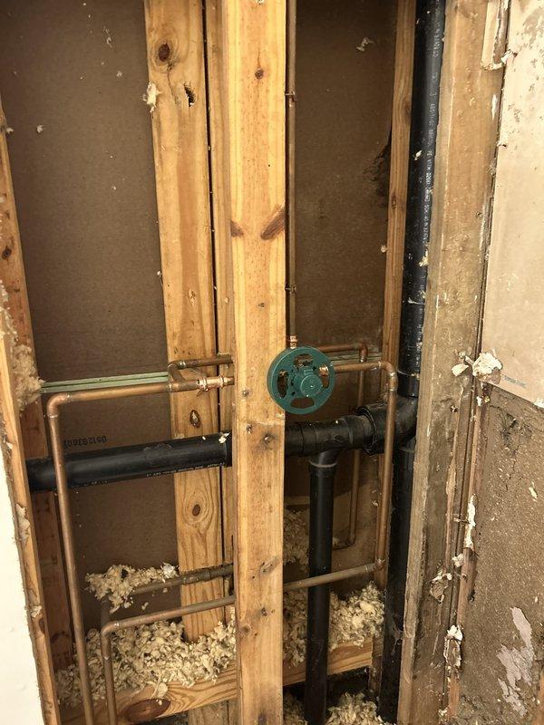 Responded to priority service call to remove existing shower fixtures in preparation for scheduled retiling work. Accessed shower valve assembly through wall cavity, disconnected and removed showerhead, trim ring, and valve handle components. Exposed plumbing infrastructure included copper supply lines and Webstone valve assembly with shutoff capability. All fixtures successfully removed to allow tile contractor access to wall surfaces while maintaining system integrity and water supply control for continued tub/shower use until renovation completion.