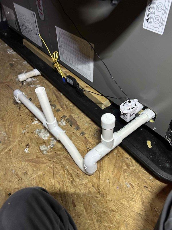 # HVAC Install Call Back - System Performance Check

Returned to recently installed HVAC system to investigate reported intermittent performance issues. Conducted thorough inspection of air handler unit and condensate drainage system in attic space. Verified condensate drain line configuration, ensuring proper trap installation and adequate venting to prevent safety switch (SS2) nuisance trips. Confirmed condensate flow is operating freely through PVC piping and trap assembly. Checked condensate pump operation and positioning. Performed system diagnostics and temperature measurements to verify proper unit operation. All components found functioning within normal parameters. System operating as designed with no issues detected during service visit.