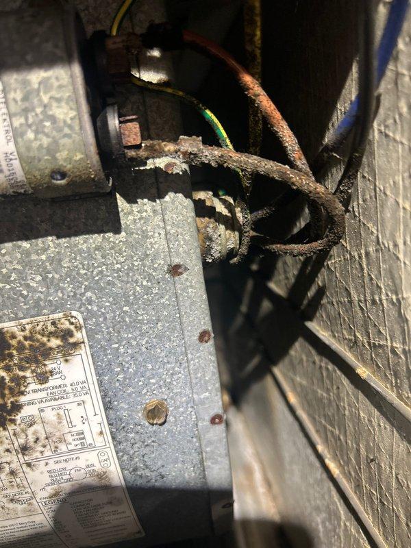 Responded to no cooling call on 13-year-old electric air conditioning system. Upon arrival, confirmed outdoor unit was not operating and indoor temperature was rising above setpoint. Visual inspection revealed catastrophic failure of contactor with severe burning and charring of electrical components. Additionally found extensive corrosion on compressor mounting hardware and deteriorated metal strapping, indicating prolonged exposure to moisture and lack of preventative maintenance. System was shut down to prevent further damage and eliminate burnt electrical odor from circulating through ductwork. Recommended complete contactor replacement and evaluation of compressor functionality once electrical components are restored, as well as assessment of outdoor unit structural integrity due to advanced corrosion.