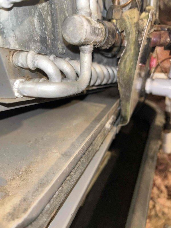 Responded to no cooling complaint on 4-year-old AC system with inadequate airflow from vents. Upon inspection, discovered severely restricted airflow due to collapsed or disconnected ductwork in crawlspace, evidenced by minimal air delivery and barely cool temperatures throughout home. Located damaged flexible ductwork beneath structure showing separation from supply plenum, along with contaminated crawlspace conditions including moisture staining on concrete floor. Inspected indoor air handler unit and found electric heat strips and coil assembly intact but unable to deliver conditioned air effectively due to compromised duct system. Documented ductwork damage and crawlspace conditions with photos for repair estimate. Advised immediate duct repair required to restore proper airflow and system cooling capacity.