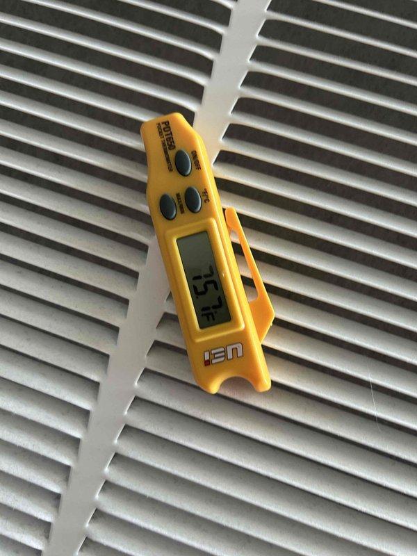 Responded to a no cooling complaint on a 5-year-old heat pump system with thermostat set to 66°F but reading 70°F. Performed diagnostic testing using digital thermometer at supply register, measuring 75.4°F discharge air temperature, and utilized clamp meter to check electrical readings on the outdoor unit. System was not maintaining adequate temperature differential, indicating insufficient cooling capacity.