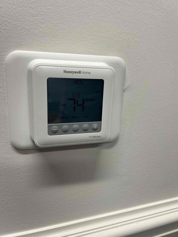 Responded to no cooling complaint on unit #2 of a 10+ year old commercial air conditioning system with ceiling-mounted indoor unit blowing warm air. Performed diagnostic inspection of the system, documented equipment nameplate information and current thermostat settings showing a setpoint of 69°F with actual temperature reading of 70.5°F and display indicating 74°F. Identified issue and completed necessary repairs to restore proper cooling operation to the affected unit.