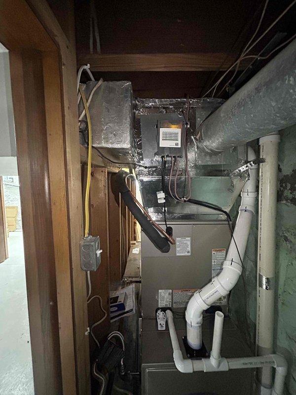 Completed full residential HVAC system installation in confined utility space with complete removal and disposal of existing equipment. Installed Carrier 60,000 BTU 90% efficiency two-stage gas furnace (model 59TN7A060C17-16), Carrier 3-ton 21 SEER2 variable-stage air conditioning unit (model 26VNA136W003), and Carrier evaporator coil (model CVAVA3617XMA) with Infinity digital thermostat for optimal system control and efficiency.

Installation included new outdoor unit pad with proper leveling, electrical whip kit, and disconnect box for code-compliant power supply to condensing unit. Installed insulated refrigerant line set with filter drier to protect system components and ensure proper refrigerant flow. Fabricated and installed transition ductwork from evaporator coil to existing duct system, along with standard-sized air filter rack for easy maintenance access.

Completed all gas furnace connections including flexible gas line connector with gas shut-off switch for safety complianc