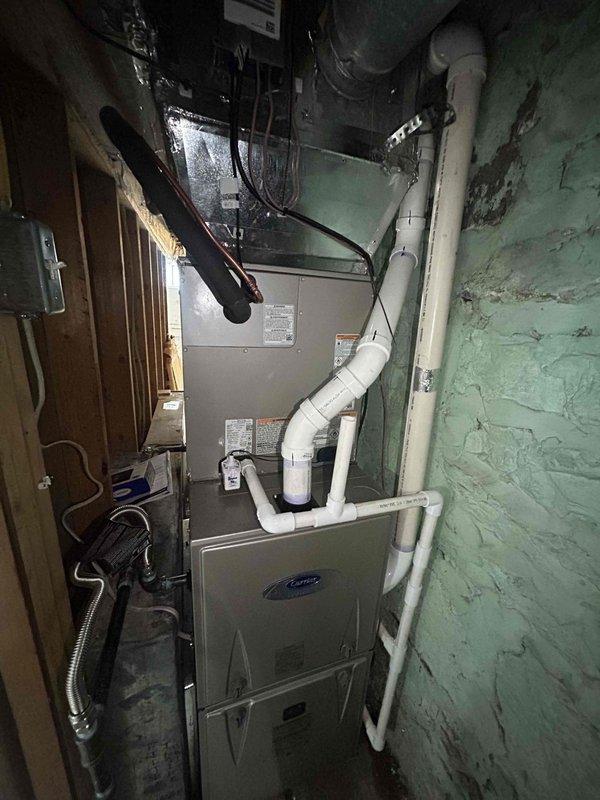 Completed full residential HVAC system installation in confined utility space with complete removal and disposal of existing equipment. Installed Carrier 60,000 BTU 90% efficiency two-stage gas furnace (model 59TN7A060C17-16), Carrier 3-ton 21 SEER2 variable-stage air conditioning unit (model 26VNA136W003), and Carrier evaporator coil (model CVAVA3617XMA) with Infinity digital thermostat for optimal system control and efficiency.

Installation included new outdoor unit pad with proper leveling, electrical whip kit, and disconnect box for code-compliant power supply to condensing unit. Installed insulated refrigerant line set with filter drier to protect system components and ensure proper refrigerant flow. Fabricated and installed transition ductwork from evaporator coil to existing duct system, along with standard-sized air filter rack for easy maintenance access.

Completed all gas furnace connections including flexible gas line connector with gas shut-off switch for safety complianc