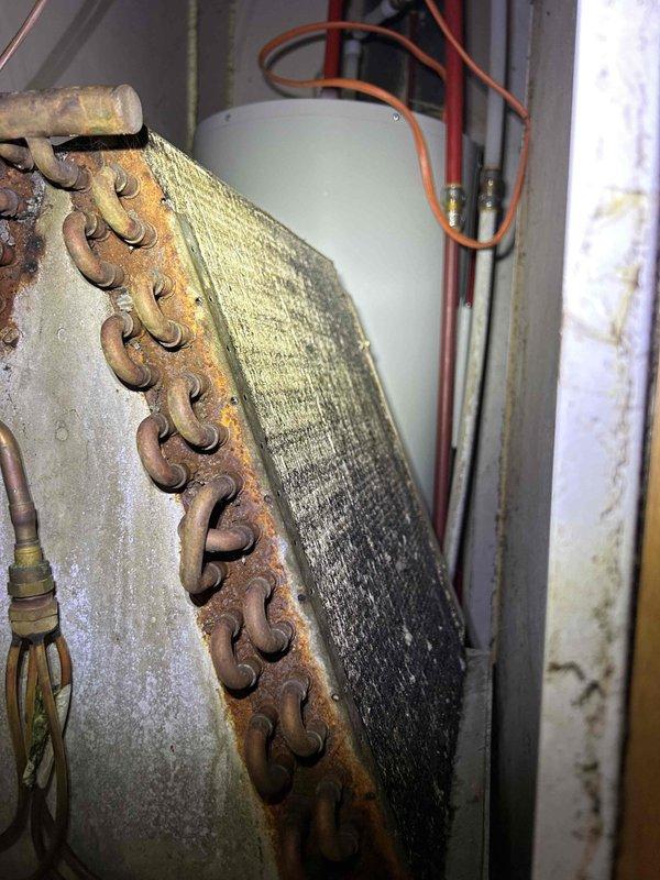 Completed routine Club Single maintenance on a 5-year-old HVAC system with indoor unit located inside the residence. During inspection, observed heavy frost accumulation on the evaporator coil and significant rust/corrosion on the copper refrigerant header piping, indicating potential airflow restriction or refrigerant flow issues requiring future attention. Documented equipment condition with photos of thermostat and indoor coil assembly for service records.