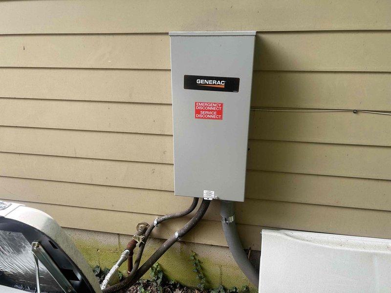 Completed routine preventative maintenance on Generac automatic transfer switch system. Performed visual inspection of transfer switch enclosure, verified proper mounting and weatherproofing integrity of exterior installation. Inspected all conduit connections and fittings at base of transfer switch for secure attachment and proper sealing. Checked warning labels and manufacturer identification plates for visibility and compliance. Examined electrical connections within transfer switch cabinet, ensuring all terminals were tight and free from corrosion. Tested transfer switch operation through simulated power failure scenario to confirm automatic switching between utility and generator power sources. Verified proper response time and sequencing of transfer operations. Photographed installation showing transfer switch mounted on building exterior with multiple conduit runs properly secured to foundation. System operating within normal parameters with no deficiencies noted. All safety lab