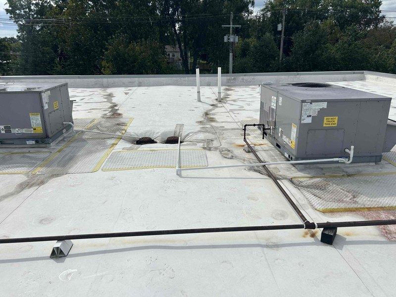 Installed new condensate drainage system on commercial flat roof, running PVC piping from two rooftop HVAC package units to existing roof drains. Utilized approximately six 10-foot sections of PVC pipe with appropriate couplings to create proper drainage pathways across the roofing membrane, ensuring condensate is directed away from equipment and discharged into designated roof drain locations. Work completed in two hours with proper pipe support and secure mounting to prevent damage to roof surface.