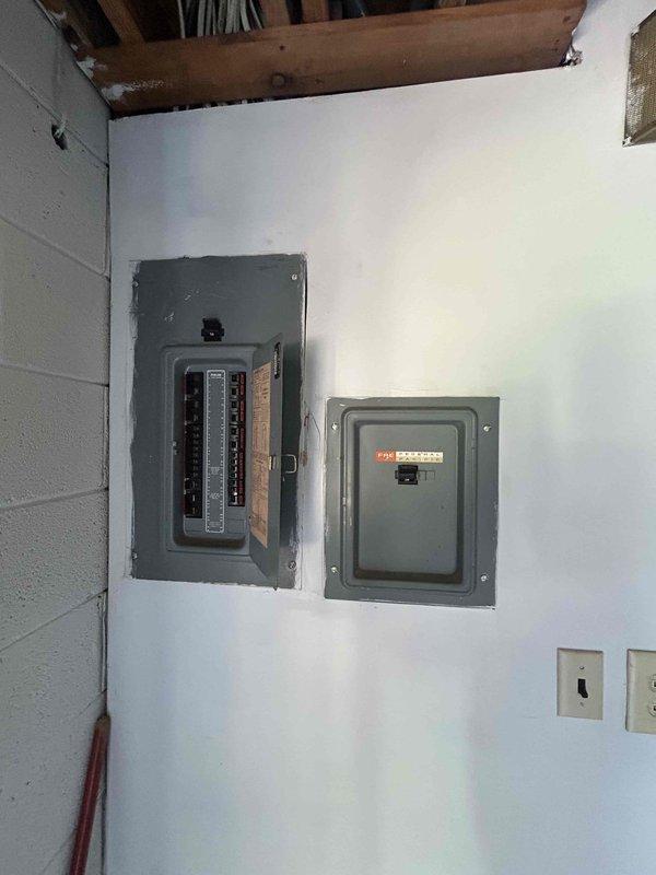 Responded to urgent no-cooling call for one-year-old Trane heat pump system. Inspected main electrical panel and distribution system in basement utility area to verify power supply to outdoor compressor unit. Documented electrical panel configuration and circuit breaker arrangement for whole-house HVAC system. Provided quote for surge protector installation to protect new heat pump equipment from electrical damage.
