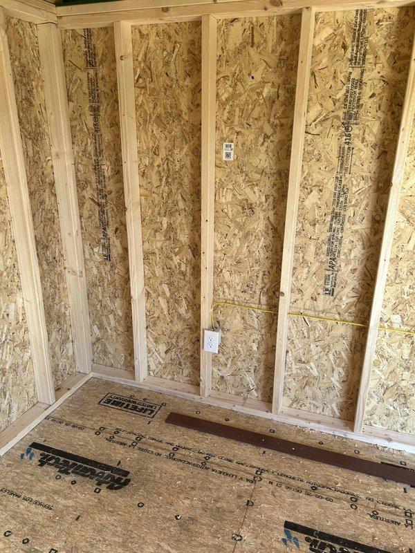 Completed rough-in electrical installation for commercial space, including installation of electrical panel with circuit breakers and proper wire routing through knockout entries. Installed outlet boxes at multiple wall locations and positioned floor registers throughout the unfinished structure with OSB walls and subflooring, ensuring all components meet code requirements for the rewiring project.