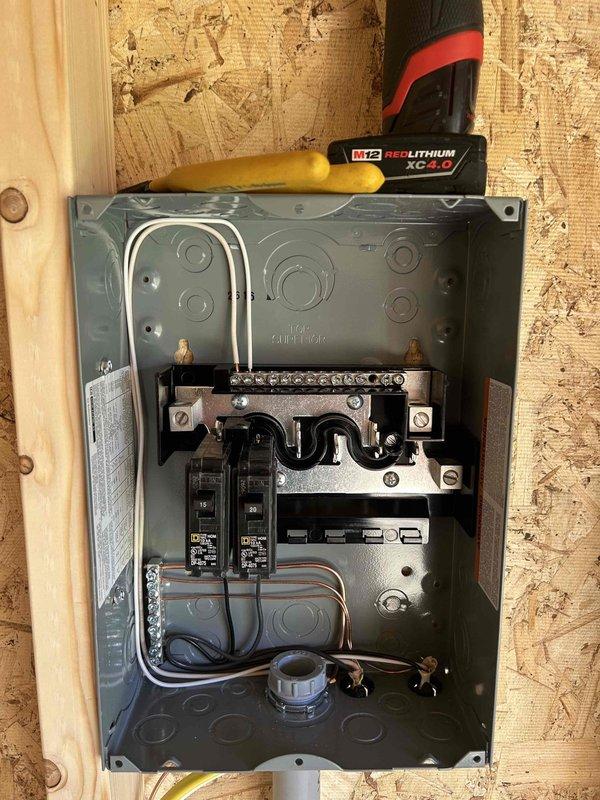 Completed rough-in electrical installation for commercial space, including installation of electrical panel with circuit breakers and proper wire routing through knockout entries. Installed outlet boxes at multiple wall locations and positioned floor registers throughout the unfinished structure with OSB walls and subflooring, ensuring all components meet code requirements for the rewiring project.