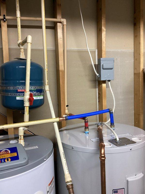 Completed installation of dual water heater system with expansion tank and associated plumbing connections. Installed copper and PVC piping with proper shut-off valves, brass fittings, and electrical disconnect. Follow-up visit scheduled to verify desuperheater pump operation on geothermal system, drill weep hole, and adjust water heater temperature setting per customer preference.