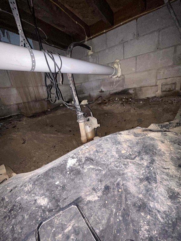 Completed plumbing inspection of basement crawl space to assess water line relocation needs and evaluate condition of existing piping system. Inspected water supply lines currently routed through wooden structural members requiring repositioning to meet code compliance and prevent future damage. Documented aging galvanized and steel pipes showing significant deterioration, corrosion, and discoloration throughout the system. Evaluated existing PVC drainage lines and mounting hardware for structural integrity. Assessed accessibility constraints within crawl space including exposed floor joists, concrete block foundation walls, and limited clearance areas. Photographed current pipe routing, support bracket locations, and areas requiring replacement to provide comprehensive documentation for estimate preparation and future repair work.