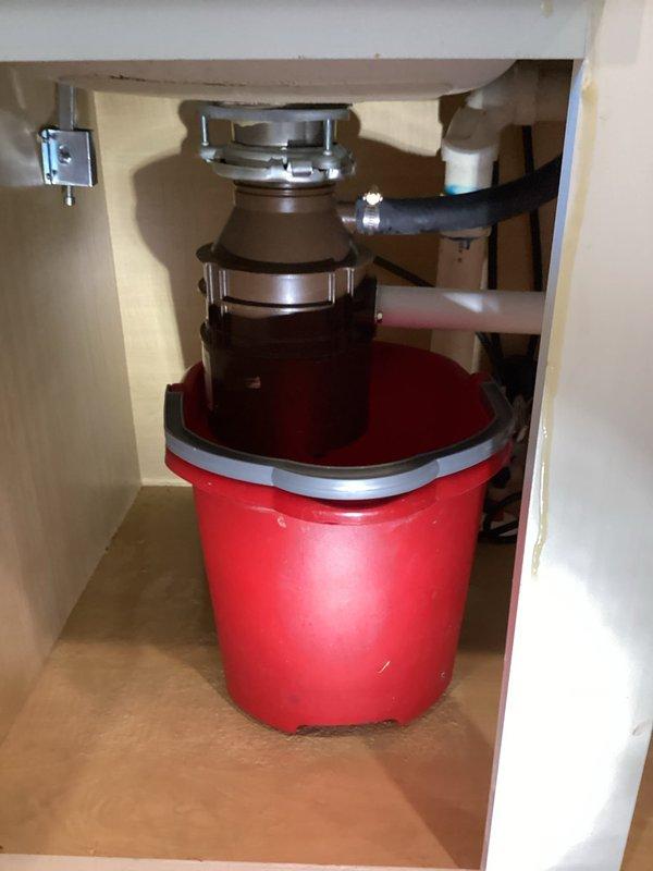 Responded to service call for jammed garbage disposal causing both kitchen sinks to back up in 7-8 year old residence. Upon inspection, found 7-year-old disposal unit inoperable with standing water in both sink basins. Accessed unit from cabinet below, assessed mounting assembly and discharge connections. Cleared jam from disposal grinding chamber and verified proper motor function. Tested unit under load with water flow to ensure complete restoration of operation. Confirmed proper drainage through P-trap assembly and verified no leaks at disposal mounting flange or discharge elbow connection. Both kitchen sinks now draining properly with disposal functioning normally.