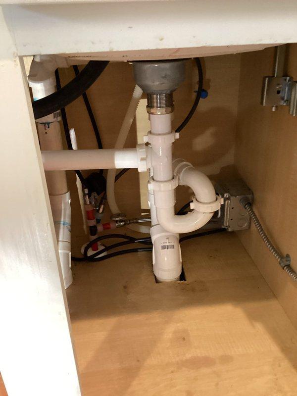 Responded to service call for jammed garbage disposal causing both kitchen sinks to back up in 7-8 year old residence. Upon inspection, found 7-year-old disposal unit inoperable with standing water in both sink basins. Accessed unit from cabinet below, assessed mounting assembly and discharge connections. Cleared jam from disposal grinding chamber and verified proper motor function. Tested unit under load with water flow to ensure complete restoration of operation. Confirmed proper drainage through P-trap assembly and verified no leaks at disposal mounting flange or discharge elbow connection. Both kitchen sinks now draining properly with disposal functioning normally.