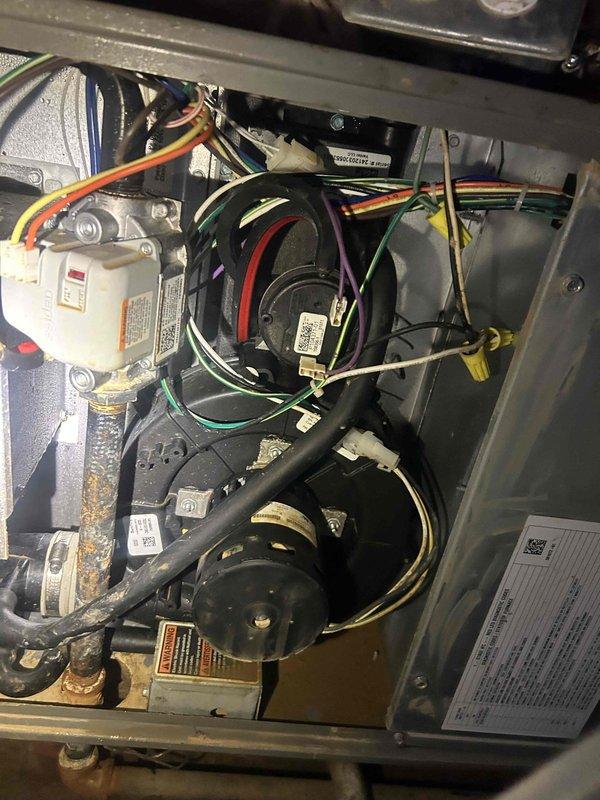 Responded to no cooling complaint on 1-year-old electric HVAC system with no airflow and green flashing light at outdoor unit. Upon inspection, found blower motor assembly failure preventing air circulation through the system. Diagnosed faulty blower motor and capacitor causing complete loss of indoor air movement while thermostat displayed 72°F actual temperature against 68°F setpoint. Accessed indoor unit compartment, disconnected electrical connections, and replaced defective blower motor assembly with OEM equivalent unit. Installed new run capacitor and verified proper wiring connections throughout blower circuit. Tested system operation, confirmed adequate airflow at all registers, and verified proper temperature differential across evaporator coil. System restored to full cooling capacity with normal operation confirmed.