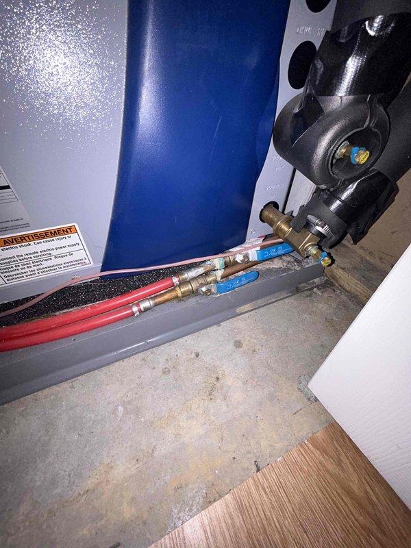 Conducted comprehensive assessment of existing 80-gallon Bradford White tank-style water heater installed in basement mechanical room serving geothermal heating system. Evaluated current unit condition, plumbing connections including PEX supply lines with brass manifold assembly, shut-off valves, and flexible connectors. Documented installation configuration with copper and insulated piping at top connections, pressure relief valve assembly, and gas supply connections. Photographed equipment specifications, warning labels, and existing plumbing infrastructure to provide accurate replacement estimate and ensure proper sizing for geothermal system integration requirements.