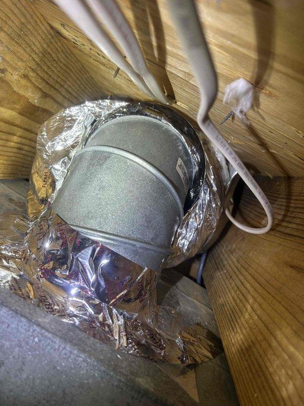 Responded to complaint of master bedroom maintaining temperature three degrees off from rest of home and excessive condensation on fresh air intake. Performed system diagnostics and inspected HVAC control board, verifying all wire connections, terminal blocks, and control sequences on Easy Select board. Examined fresh air intake ductwork penetration through attic framing, noting existing foil tape wrap at wooden beam interface. Assessed airflow balance, damper positioning, and zone control functionality to address temperature differential in master bedroom.