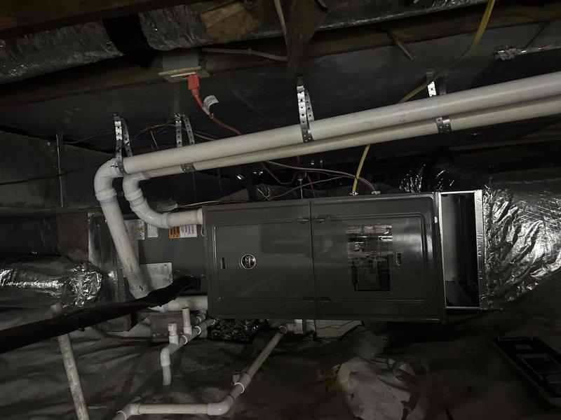 Completed comprehensive HVAC maintenance inspection on dual fuel system located in crawlspace environment. Performed thorough evaluation of air handler unit, verified proper operation of condensate drainage system with PVC piping configuration, and inspected insulated flexible ductwork connections on both supply and return sides. All components found operating within normal parameters, with equipment properly secured to floor joists and adequate clearances maintained for service access.