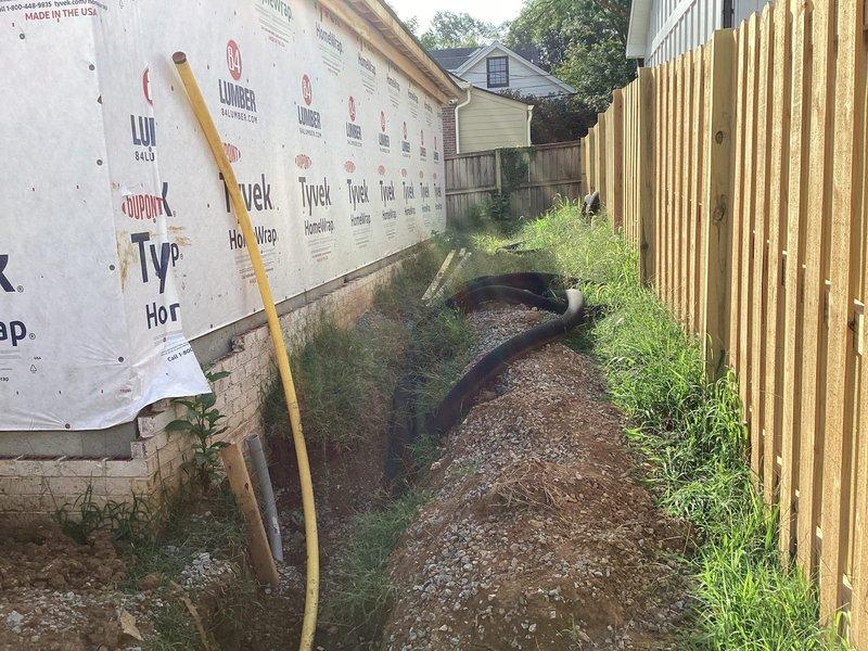 Conducted comprehensive electrical estimate for generator installation at residential property currently under construction. Assessed existing electrical infrastructure including dual panel boxes mounted on exposed wall framing with spray foam insulation, evaluating capacity and compatibility for generator integration. Documented exterior site conditions including drainage pathway with corrugated pipes and available space between structures for potential generator placement. Photographed electrical panels showing multiple wire runs and circuit configurations to determine connection requirements and transfer switch specifications needed for backup power system installation.
