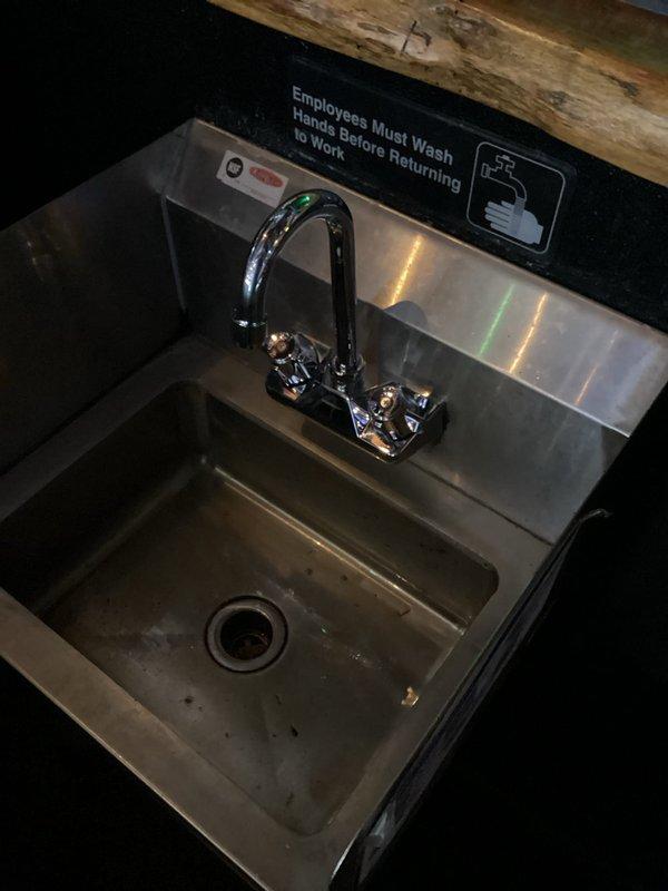 Replaced existing chrome faucet with customer-supplied unit on commercial hand-washing sink located behind bar area. Disconnected old dual-handle faucet assembly, removed mounting hardware, and installed new faucet per manufacturer specifications. Verified water supply connections and tested for proper operation and leak-free performance upon completion.
