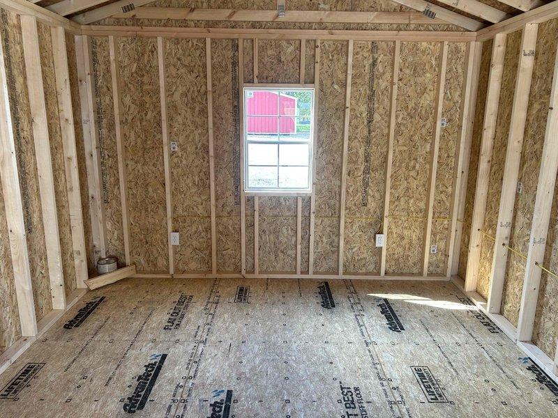 Completed electrical rough-in installation for new construction outbuilding, installing GFCI receptacle, standard duplex outlet, single-pole switch, keyless light fixture with bulb, and SJ cord with male cord cap. Routed black electrical cable vertically through wall cavities between studs, mounted outlet boxes to framing members per code requirements, and verified all connections prior to insulation and drywall installation.