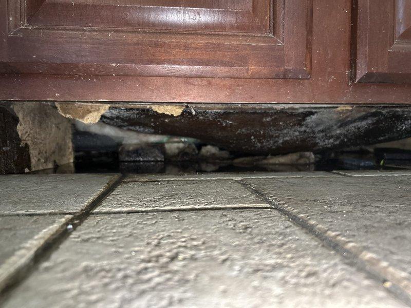 Responded to water leak complaint originating from kitchen sink area. Upon investigation, discovered active water intrusion in crawl space above kitchen with visible water droplets falling onto wooden subflooring. Traced leak source to compromised plumbing connection serving kitchen sink. Identified severe water damage to wooden cabinet base and subflooring materials beneath kitchen sink cabinet, including deteriorated wood with significant structural compromise and damaged substrate materials. Repaired faulty plumbing connection, stopped active leak, and verified system integrity. Documented extensive water damage to cabinetry and flooring for insurance purposes. Recommended immediate remediation of water-damaged materials to prevent mold growth and further structural deterioration.