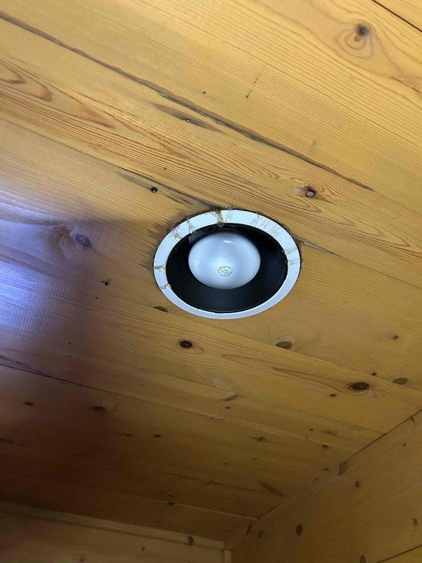 Responded to service call for geothermal HVAC system experiencing severe condensation issues affecting indoor units located in basement and attic. Upon arrival, identified excessive water accumulation throughout the system with moisture damage extending from upper level down to basement level. Documented extensive water damage to wood flooring showing buckling and structural compromise. Inspected recessed lighting fixtures in wooden ceiling areas for potential moisture intrusion. Photographed affected areas including hardwood flooring damage and ceiling conditions to document extent of water infiltration from condensation failure.