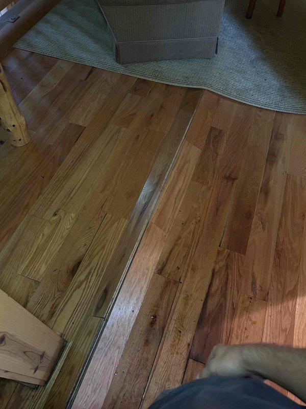 Responded to service call for geothermal HVAC system experiencing severe condensation issues affecting indoor units located in basement and attic. Upon arrival, identified excessive water accumulation throughout the system with moisture damage extending from upper level down to basement level. Documented extensive water damage to wood flooring showing buckling and structural compromise. Inspected recessed lighting fixtures in wooden ceiling areas for potential moisture intrusion. Photographed affected areas including hardwood flooring damage and ceiling conditions to document extent of water infiltration from condensation failure.