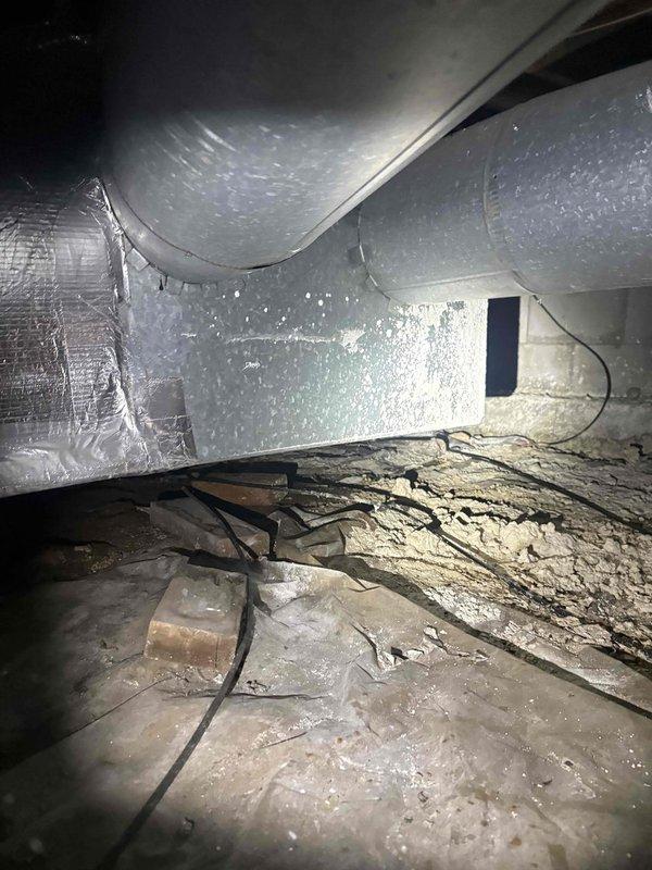 Responded to no cooling call on aging gas furnace/AC system with indoor unit located in crawlspace. Upon arrival, confirmed system was blowing warm air instead of conditioned air. Accessed crawlspace unit through confined entry point and performed diagnostic evaluation of both indoor air handler and outdoor condensing unit. Inspected ductwork, refrigerant lines, electrical connections, and thermostat communication. Documented existing conditions of crawlspace installation including insulation displacement and overall system accessibility challenges typical of older installations in confined spaces.