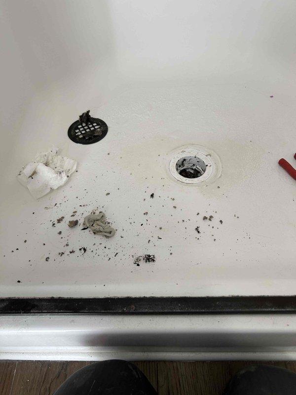 Responded to steady water leak reported in kitchen ceiling. Upon investigation, traced source to second-floor bathroom directly above affected area. Inspection revealed compromised shower pan drain assembly with failed seal allowing continuous water infiltration through subfloor into kitchen ceiling below. Removed existing drain cover and assessed extent of deterioration. Disassembled drain components, cleaned debris and buildup from shower pan surface, and replaced defective drain gasket and sealing components. Reinstalled drain assembly with proper sealant application to ensure watertight connection. Tested system with water flow to verify leak elimination and confirm proper drainage function.