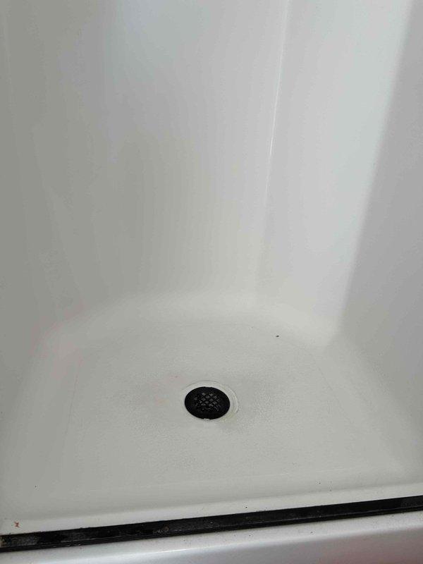 Responded to steady water leak reported in kitchen ceiling. Upon investigation, traced source to second-floor bathroom directly above affected area. Inspection revealed compromised shower pan drain assembly with failed seal allowing continuous water infiltration through subfloor into kitchen ceiling below. Removed existing drain cover and assessed extent of deterioration. Disassembled drain components, cleaned debris and buildup from shower pan surface, and replaced defective drain gasket and sealing components. Reinstalled drain assembly with proper sealant application to ensure watertight connection. Tested system with water flow to verify leak elimination and confirm proper drainage function.