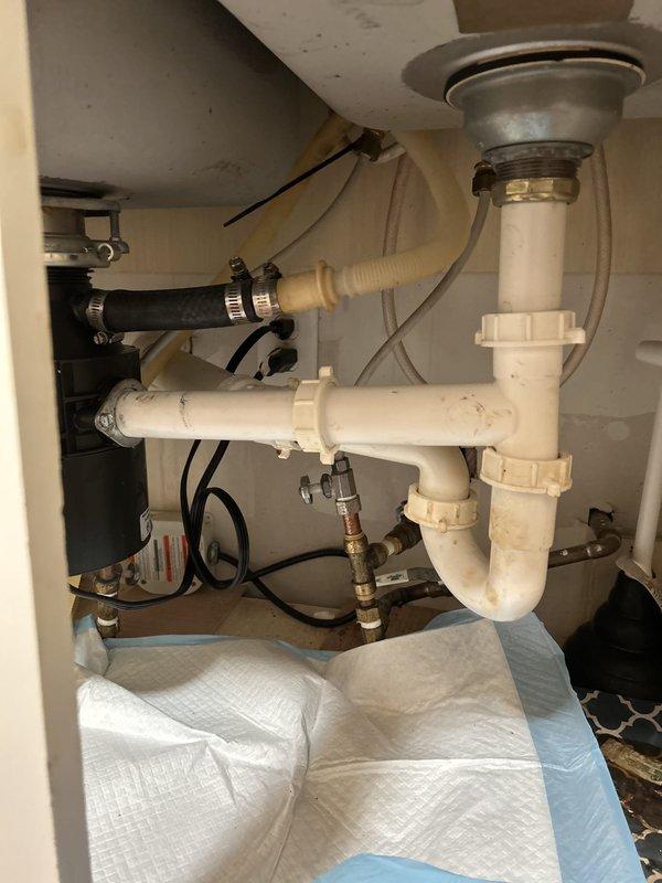 Responded to service call for non-operational garbage disposal unit with no humming noise. Upon inspection, found 5-year-old 1.3 horsepower disposal unit completely unresponsive, indicating electrical failure or motor seizure. Removed and replaced defective garbage disposal unit with new assembly, reconnecting all drain lines, dishwasher discharge hose, and electrical supply. Verified proper P-trap configuration, tested all connections for leaks, and confirmed new unit operates correctly with full grinding capability.