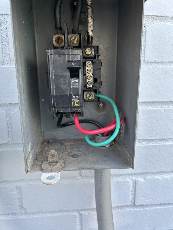 Replaced damaged outdoor electrical disconnect serving commercial HVAC condenser unit with new 60-amp Square D QO series disconnect switch. Removed old weathered disconnect panel, installed new enclosure on exterior concrete block wall, and reconnected all power conductors and grounding wires to proper terminals within the new disconnect box.