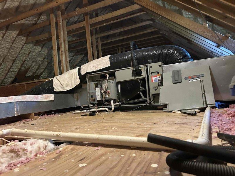 Responded to service call for clogged condensate drain line with leaking drain pan. Upon arrival, accessed air handler unit in attic space and confirmed AC system was operating and cooling properly. Inspection revealed accumulated debris and sediment in the condensate drain pan, with visible dirt buildup indicating drainage restriction. Cleared clog from condensate drain line to restore proper drainage flow and prevent overflow conditions. Cleaned drain pan of accumulated debris and verified proper condensation evacuation. System returned to normal operation with condensate draining freely through primary drain line.