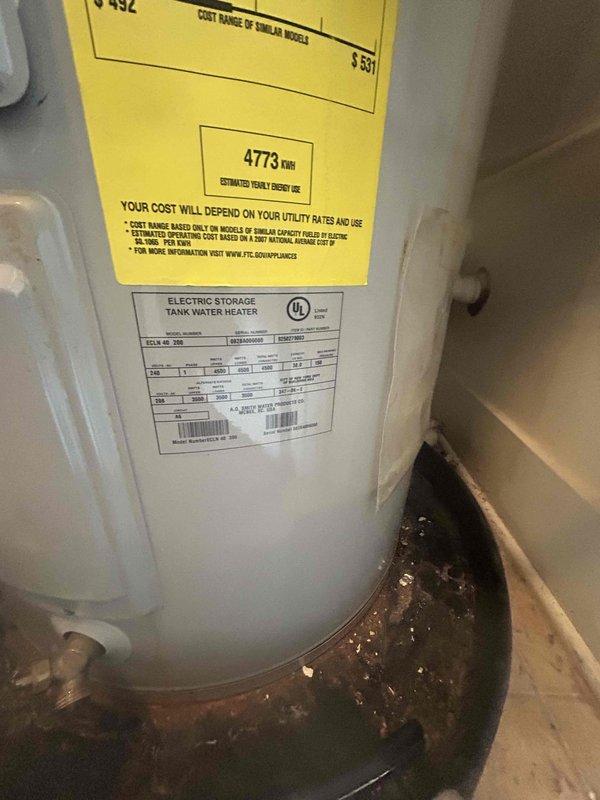 Performed comprehensive assessment of existing 38-gallon short electric storage tank water heater located in utility closet. Documented current unit specifications and installation conditions through photographic evidence. Inspection revealed significant rust and corrosion on drip pan beneath water heater, with extensive water damage and staining present on surrounding flooring materials including both tile and adjacent hardwood surfaces. Observed moisture-related discoloration extending from base of unit, indicating active or recent leaking condition. Evaluated utility closet installation space, clearances, and existing plumbing connections to provide accurate replacement estimate for customer consideration of tank or tankless water heater options.