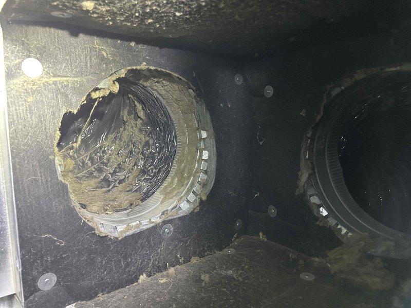 Responded to service call for system blowing warm air through vents despite cold air present at crawlspace unit. Upon arrival, inspected outdoor condenser unit and found it properly secured within protective cage against building exterior. Conducted internal system inspection revealing significant accumulation of dust, debris, and fibrous material within ductwork and air handler components, indicating extended period without maintenance. Documented equipment condition showing deteriorated interior surfaces with lint and particulate buildup affecting airflow distribution, which explained temperature differential between supply air at unit and delivery through registers.
