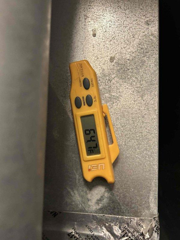 Responded to no cooling complaint on 5-year-old electric HVAC system unable to maintain temperature below 77°F. Performed diagnostic evaluation of basement-located indoor unit and measured supply air temperatures at ductwork. Temperature readings indicated 67°F and 54.3°F at supply plenum, confirming adequate cooling capacity and proper system operation with approximately 13-21°F temperature split from typical return air conditions.