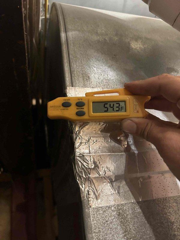 Responded to no cooling complaint on 5-year-old electric HVAC system unable to maintain temperature below 77°F. Performed diagnostic evaluation of basement-located indoor unit and measured supply air temperatures at ductwork. Temperature readings indicated 67°F and 54.3°F at supply plenum, confirming adequate cooling capacity and proper system operation with approximately 13-21°F temperature split from typical return air conditions.
