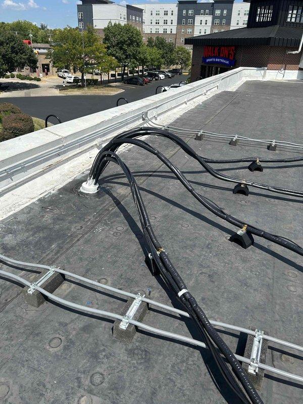 Returned to site to replace temporary post blockers under refrigerant linesets with permanent Durablock supports on commercial rooftop HVAC installation. Successfully installed proper elevation blocks beneath curved lineset runs to ensure adequate clearance from roof membrane and maintain professional appearance of mechanical system routing.