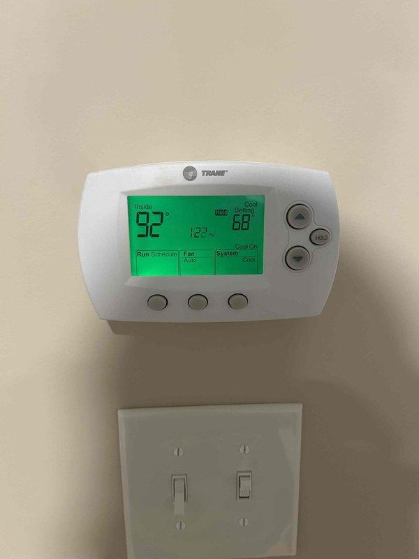 Responded to service call for non-cooling complaint and performed leak search on HVAC system. Upon inspection, found unit completely void of refrigerant, indicating a significant leak in the system. Documented thermostat displaying 92°F ambient temperature with setpoint at 68°F, confirming lack of cooling capacity, and recorded supply air temperature readings to verify no refrigerant in system.