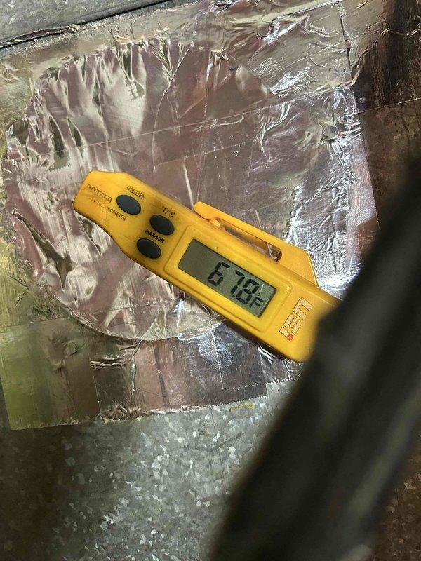 # HVAC Service Completed

Responded to no cooling complaint on 3-year-old electric heat pump system. Customer reported unit blowing warm air and running constantly with thermostat set to 74°F while indoor temperature reached 80°F. No electrical issues, ice buildup, or frost observed on equipment.

Upon inspection, discovered significant airflow restriction caused by severely deteriorated ductwork and accumulated debris in supply plenum. Interior duct examination revealed extensive buildup of decomposed insulation material, dirt, and foreign matter obstructing airflow path. Contaminated insulation and debris layer measuring several inches deep found at bottom of duct system, reducing effective air passage by approximately 40-50%.

Documented ductwork condition with interior photographs showing corrugated metal duct with visible moisture damage, staining, and material deterioration. Observed green piping sections embedded in debris field along with blackened insulation remnants and granu