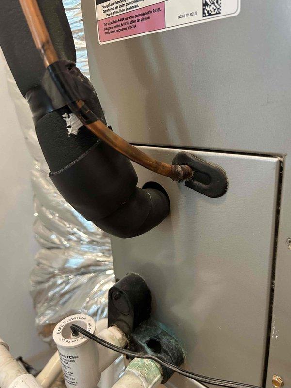 Responded to water leak at indoor air handler unit located in closet. Upon inspection, found condensate drain line had separated at connection point, causing water damage to surrounding flooring and ductwork. Disassembled and removed damaged drain line components. Cleaned and prepared connection points, then reinstalled new PVC drain line with proper fittings and secure connections. Verified proper drainage flow and tested system operation. Inspected air handler unit and surrounding copper refrigerant lines for any additional moisture damage or corrosion. Confirmed unit operational and condensate draining properly into drain pan and through newly installed drain line without leaks.
