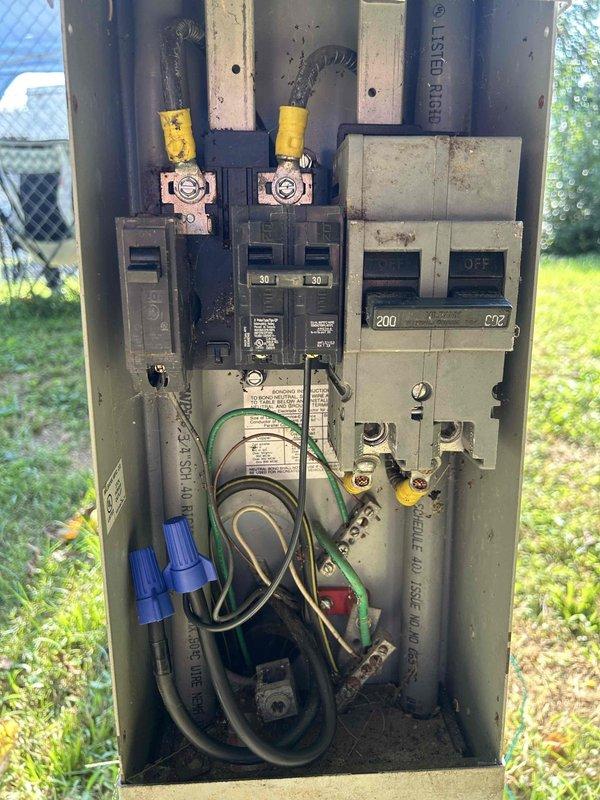 Performed electrical inspection of outdoor RV/camper service panel and discovered improper meter installation. The existing meter is rated for mobile home use rather than camper application, creating a code compliance and safety issue. The current configuration includes a weatherproof outlet box mounted on PVC post with multiple circuit breakers and copper bus bars inside the main panel enclosure. Recommended complete rewiring of the camper meter installation to meet proper electrical standards and ensure safe operation for the intended RV/camper application.