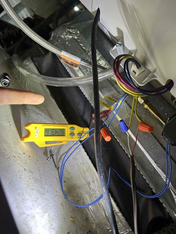 Completed annual maintenance on residential geothermal HVAC system consisting of two geothermal units, one air handler located in attic, and one humidifier as part of recurring service agreement. Performed comprehensive inspection of air handler unit with visual assessment of cabinet condition, filter housing, and ductwork connections. Conducted diagnostic testing using digital multimeter to verify operational parameters, recording temperature differential of -1.8 degrees. Inspected blower motor assembly, heat exchanger components, and electrical connections including wire terminations and safety controls. Verified proper operation of condensate drainage system with yellow flexible drain line and blue fittings. All equipment found operating within normal parameters with no deficiencies noted. System performing as designed with proper airflow through ductwork and satisfactory component function throughout attic-mounted installation.