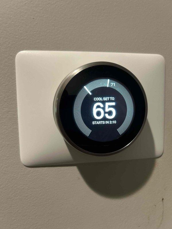 Responded to no cooling complaint on electric HVAC system with indoor unit located in attic. Upon arrival, thermostat was set to 70°F with indoor temperature reading 76°F. Performed system diagnostic and inspected air filter, which showed moderate accumulation of dust and debris with visible yellow particulate matter throughout pleated media. Replaced dirty air filter with new filter to restore proper airflow. Adjusted thermostat cooling setpoint to 65°F to bring system online. Verified system startup sequence initiated properly with 2-minute delay timer engaged for compressor protection. System operational at time of departure.