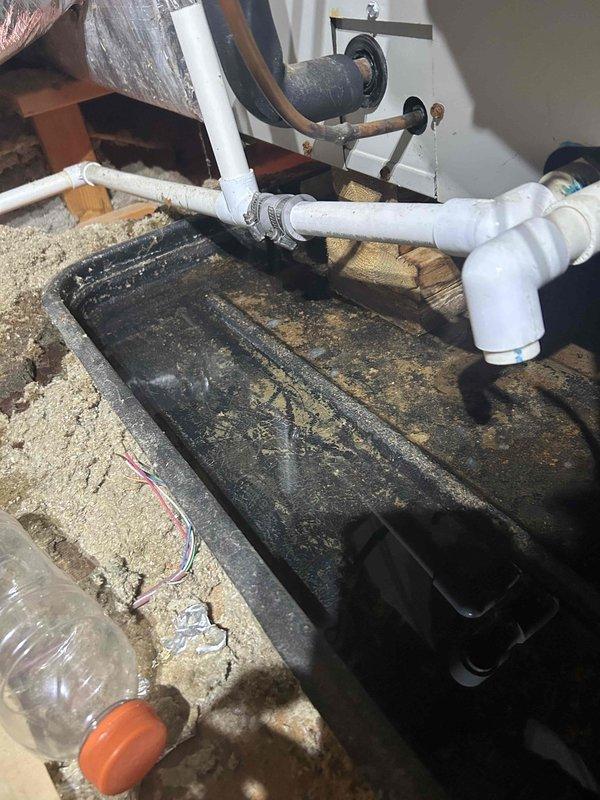 Responded to callback for missed condensate leak that caused drywall damage since initial visit. Located active leak in attic HVAC system, inspected drain pan showing signs of overflow and staining, and evaluated PVC condensate line routing with multiple elbows. Documented damage to interior stairway where drywall debris had accumulated on carpeted steps and landing. Photographed attic installation including drain pan positioning, condensate piping configuration, and affected areas for board quote preparation.