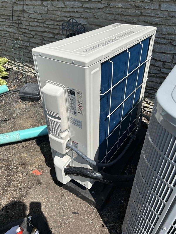 Completed full installation of Mitsubishi 24K BTU Hyper Heat mini split system consisting of MUZ-GX24NLHZ outdoor condenser unit and MSZ-GX24NL indoor wall-mounted air handler. Installed outdoor unit on concrete pad with vibration dampening and snow legs for elevated positioning. Mounted indoor wall unit in covered outdoor entryway area with refrigerant lines routed along exterior wall. Ran and insulated refrigerant line set between indoor and outdoor units. Installed dedicated electrical circuit including disconnect box and electrical whip kit for proper power supply to system. Completed all electrical connections, refrigerant charging, and system commissioning. Tested system operation and verified proper heating and cooling performance. Obtained necessary permits and ensured all work met code compliance standards. Removed and disposed of existing equipment. Enrolled system in annual care maintenance plan for ongoing service.