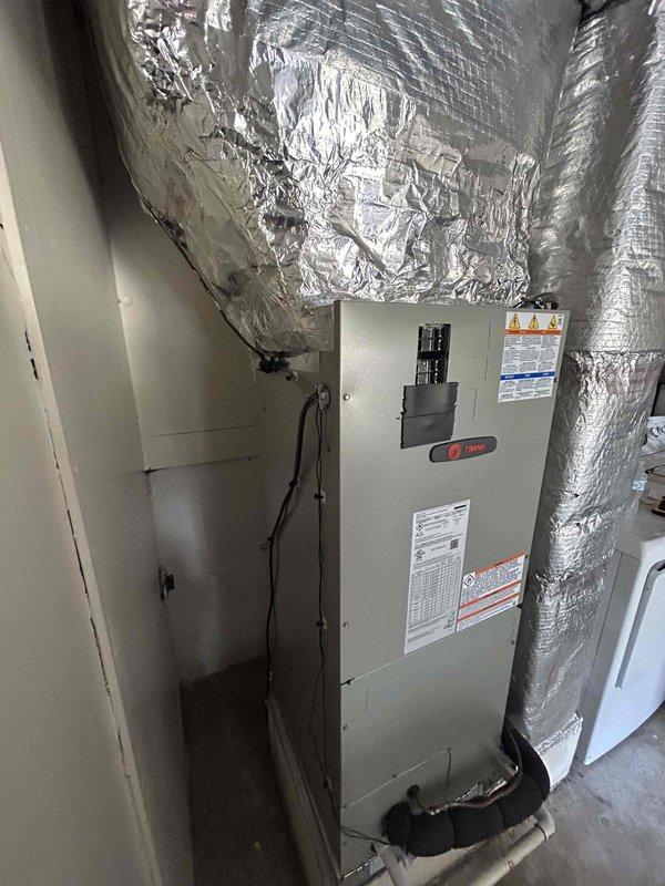 Completed full residential HVAC system installation featuring a Trane 14.3 SEER2 2.5-ton heat pump with matching air handler and auxiliary heat kit. Installed outdoor unit on concrete pad with snow legs, electrical disconnect box, and whip kit with proper refrigerant line insulation and filter. Air handler positioned in interior utility closet with flexible ductwork connections, condensate trap, SS2 coil drain safety sensor, ceiling saver overflow pan with water sensor, and standard filter rack with transition to existing ductwork. Installed digital programmable thermostat with lockout settings configured to 76°F heating and 72°F cooling per specifications. All electrical connections completed with conduit run to air handler, system charged and tested for proper operation. Enrolled system in preventative maintenance care plan including bi-annual inspections and extended warranty coverage.
