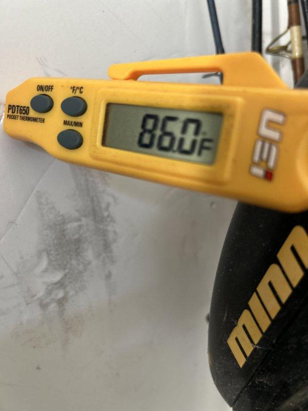 Responded to customer callback regarding insufficient cooling and concerns about compressor operation. Upon arrival, verified system was running but unable to maintain setpoint, with indoor temperature holding at 77°F. Performed comprehensive system diagnostics using digital manifold gauges and temperature measurements. Refrigerant pressures indicated system was operational with suction pressure reading 38.5 PSIG and subcooling at 8.6°F. Discharge line temperature measured 86°F, confirming compressor was actively pumping. System demonstrated adequate cooling capacity with 27°F temperature differential across evaporator coil. Determined compressor and refrigerant circuit functioning within normal parameters. Advised customer that gradual temperature reduction of 3 degrees over 4 hours is consistent with system recovery during extreme ambient conditions and undersized equipment for space load. System operating as designed with no mechanical failures identified.
